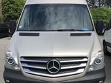 Le monospace Mercedes est garé sur un parking, à côté d'autres voitures.