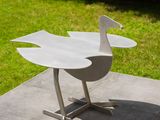 a bird that is sitting on a table in the yard