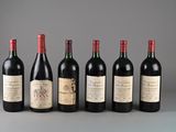 six bottles of wine are lined up in a row on a table