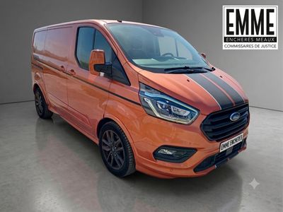 La camionnette orange est garée dans un garage et porte une bande noire.