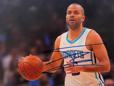 photo dédicacée d'un basketteur tenant un ballon de basket devant un public