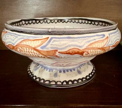 un bol orné d'un motif de poisson, posé sur une table