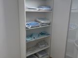 une salle de bains avec une paroi de douche en verre et une étagère avec des serviettes