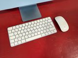 a keyboard and mouse on a red desk next to a monitor