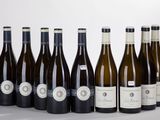six bottles of wine are lined up in a row on a table