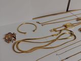 a lot of gold necklaces and bracelets on a table