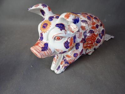 une petite figurine représentant un cochon avec des fleurs sur la tête