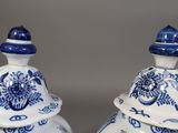 two blue and white vases sitting on a table