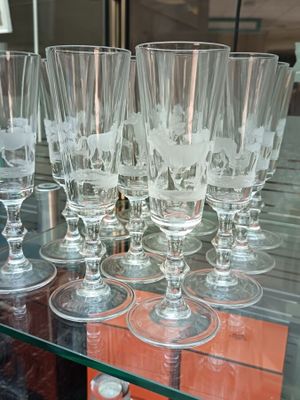 many wine glasses on a glass shelf in a store