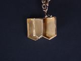 a silver and gold necklace with a book on it