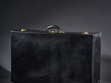 a black suitcase sitting on top of a table next to a wall