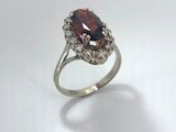 a close up of a silver ring with a red stone