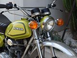 a green and black motorcycle parked in front of a building