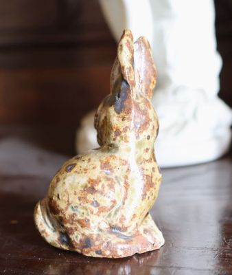 une petite statue représentant un lapin assis sur une table