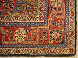an old rug with a red and blue design on a white floor