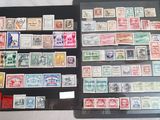 two folders of different stamps are sitting on a table