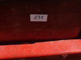 une boîte rouge sur laquelle figure un numéro, posée sur un banc