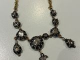 a close up of a necklace on a white surface
