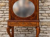 a small wooden cabinet with a mirror on it