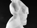 black and white photograph of a figurine of a woman sitting on a stool