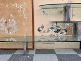 a glass table with birds on it in front of a wall