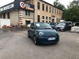 a small blue car parked in front of a building
