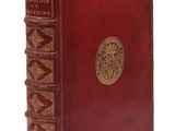 un vieux livre rouge orné d'un médaillon doré sur la couverture