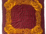 red and yellow square scarf with gold chains on a red and black checkered background