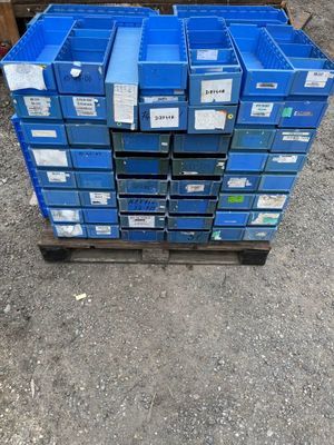 a stack of blue crates sitting on top of a wooden pallet