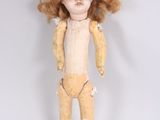 an image of a doll with red hair standing on a white surface