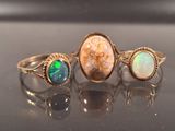 three rings with oplite and oplite stones on a table