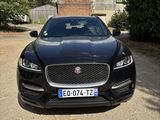 the front end of a black jaguar car parked in a driveway