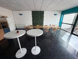 une pièce équipée de tables et de chaises, d'où l'on peut voir l'extérieur