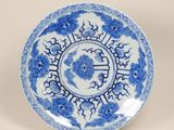 assiette bleue et blanche ornée d'un motif floral sur le bord