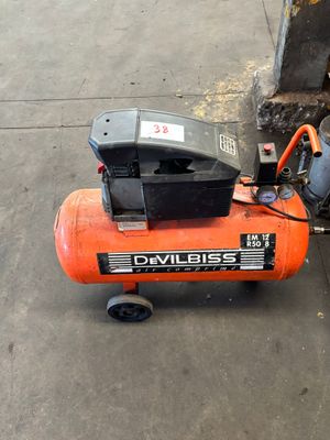 un petit compresseur d'air posé sur le trottoir à côté d'une borne d'incendie