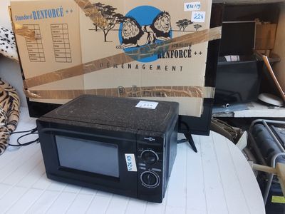 un micro-ondes posé sur une table devant une boîte