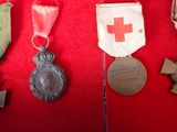 several medals and medals are displayed on a red cloth