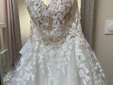 wedding dress hanging on a hanger in front of a window