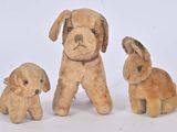 trois peluches assises les unes à côté des autres sur une surface blanche
