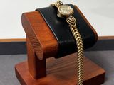 montre-bracelet posée sur un support en bois muni d'une chaîne