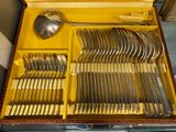 une boîte jaune contenant un service d'argenterie