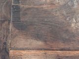 a close up view of a wooden floor with peeling paint on it