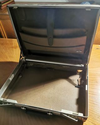 a suitcase sitting on a table with a laptop in it