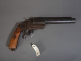 un vieux pistolet muni d'une étiquette, posé sur une surface grise