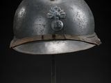 an old helmet on a metal stand with a black background