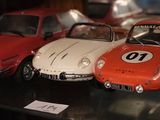 Plusieurs petites voitures sont exposées dans une vitrine.