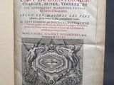 un livre ouvert sur lequel figure un blason