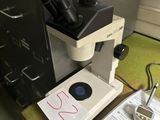 un microscope posé sur un bureau, à côté d'un classeur