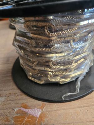un gros plan d'une bobine de fil posée sur une table en bois
