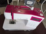 une machine à coudre rose et blanche posée sur une table